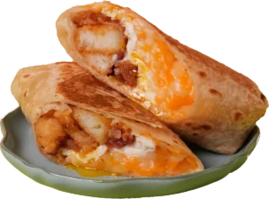 Breakfast burrito with fried eggs, sausage, melted cheese, peppers, onions, tots, guacamole, and sriracha aioli.